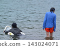 A man and a girl, both wearing swimsuits and backpacks, are swimming in the bay. A man and a girl, both wearing swimsuits and backpacks, are swimming in the bay. 143024071