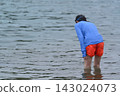 A man and a girl, both wearing swimsuits and backpacks, are swimming in the bay. A man and a girl, both wearing swimsuits and backpacks, are swimming in the bay. 143024073