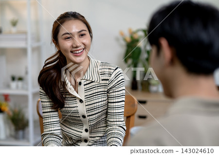 Asian Woman Smiling Warmly in Conversation with Partner at Home Asian Woman Smiling Warmly in Conversation with Partner at Home 143024610