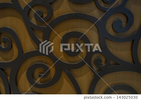 Black iron arabesque ornament pattern on wood background Black iron arabesque ornament pattern on wood background 143025030