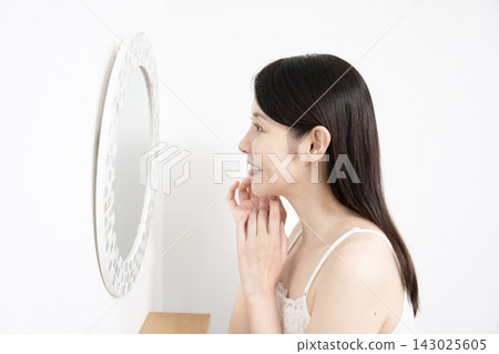 一位嫁接了睫毛的女士正在照鏡子。 143025605