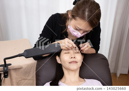 接受睫毛延長治療的婦女 接受睫毛延長治療的婦女 143025660