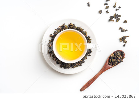 Top view of loose oolong tea leaves on bamboo holder and tea cup with leaf isolated on white background with copy space Top view of loose oolong tea leaves on bamboo holder and tea cup with leaf isolated on white background with copy space 143025862