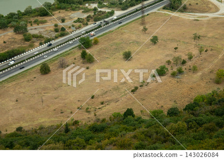 Aerial perspective shows highway traffic alongside a mix of green and dry land Aerial perspective shows highway traffic alongside a mix of green and dry land 143026084