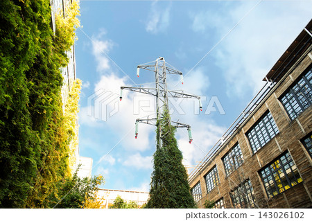 Power lines rise amidst lush greenery in a modern urban environment Power lines rise amidst lush greenery in a modern urban environment 143026102