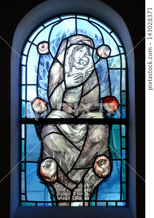 Virgin Mary with baby Jesus, stained glass window by Sieger Koder in chapel in Hinterbrand, Germany Virgin Mary with baby Jesus, stained glass window by Sieger Koder in chapel in Hinterbrand, Germany 143028371
