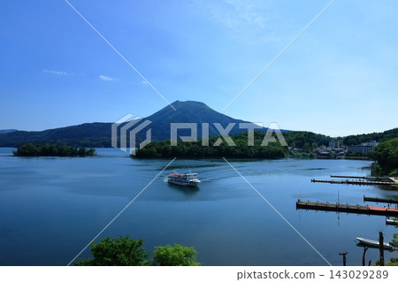 A sightseeing boat on Lake Akan with a view of Mount Oakan and a magnificent blue sky. A sightseeing boat on Lake Akan with a view of Mount Oakan and a magnificent blue sky. 143029289