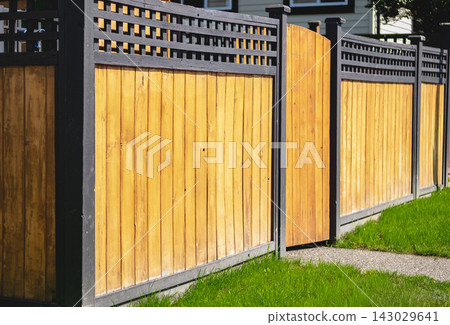 New wooden fence with green grass lawn around the house in residential area New wooden fence with green grass lawn around the house in residential area 143029641
