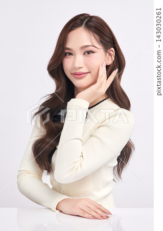 A beautiful young Asian woman with clean, fresh skin against a white background. Skincare, facial treatment, cosmetology, beauty, and spa. An elegant portrait of an Asian woman. A beautiful young Asian woman with clean, fresh skin against a white background. Skincare, facial treatment, cosmetology, beauty, and spa. An elegant portrait of an Asian woman. 143030261