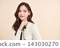 A beautiful young Asian woman with clean, fresh skin against a beige background. Skincare, facial treatment, cosmetology, beauty, and spa. An elegant portrait of an Asian woman. 143030270