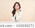 A beautiful young Asian woman with clean, fresh skin against a beige background. Skincare, facial treatment, cosmetology, beauty, and spa. An elegant portrait of an Asian woman. 143030271