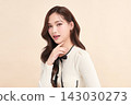 A beautiful young Asian woman with clean, fresh skin against a beige background. Skincare, facial treatment, cosmetology, beauty, and spa. An elegant portrait of an Asian woman. 143030273