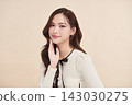 A beautiful young Asian woman with clean, fresh skin against a beige background. Skincare, facial treatment, cosmetology, beauty, and spa. An elegant portrait of an Asian woman. 143030275
