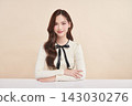 A beautiful young Asian woman with clean, fresh skin against a beige background. Skincare, facial treatment, cosmetology, beauty, and spa. An elegant portrait of an Asian woman. 143030276