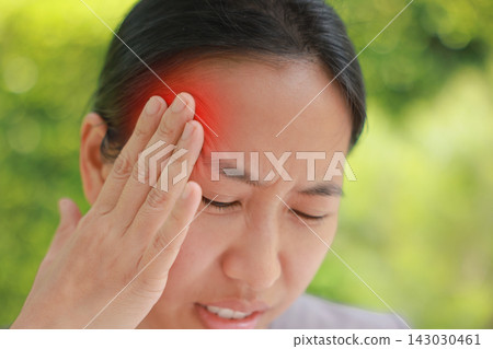 Unhappy young Asian woman touching head with red highlighted area indicating severe headache, migraine, or brain pain. Concept of stress, sickness, healthcare, tension and mental health problem. Unhappy young Asian woman touching head with red highlighted area indicating severe headache, migraine, or brain pain. Concept of stress, sickness, healthcare, tension and mental health problem. 143030461