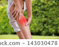 Close up of person holding bare calf muscle with red highlighted area indicating severe leg pain, muscle cramp, strain, or sports injury. Healthcare, physical therapy, and medical concept outdoors. 143030478