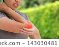 Close up unhappy Asian woman touching her elbow with a red highlighted area indicating severe joint pain, arthritis, muscle ache or sports injury. Healthcare, physical therapy, and medical concept. 143030481