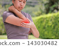 Close up unhappy Asian woman touching her elbow with a red highlighted area indicating severe joint pain, arthritis, muscle ache or sports injury. Healthcare, physical therapy, and medical concept. 143030482