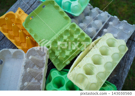 Eco friendly egg containers made of recycled paper pulp on wooden background Eco friendly egg containers made of recycled paper pulp on wooden background 143030560