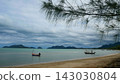 Small Fishing Boats Floating in Calm Sea Near Sandy Beach Under Cloudy Sky 143030804