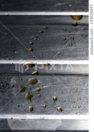 Drops of cooking fat oil liquid spilt on a stainless steel kitchen sink messy food preparation 143030847