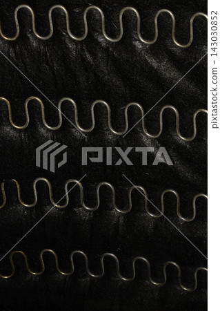 Zigzag curved couch sofa springs used metal wavy silver lines on black fabric background Zigzag curved couch sofa springs used metal wavy silver lines on black fabric background 143030852