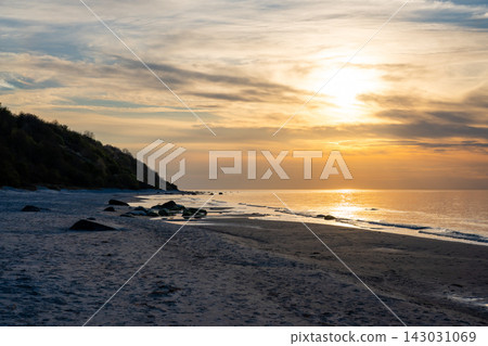 Rocky beach coastline on Ruegen island in Germany during sunset over the Baltic Sea. Travel, nature and seaside landscape with calm evening atmosphere 143031069
