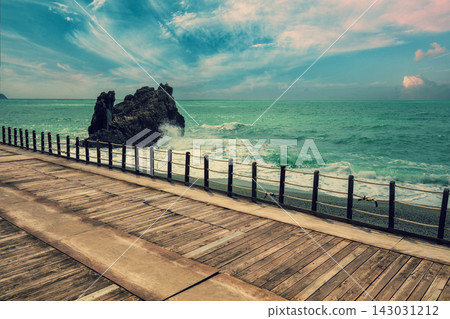 Deserted beach in stormy weather. Wooden embankment Deserted beach in stormy weather. Wooden embankment 143031212