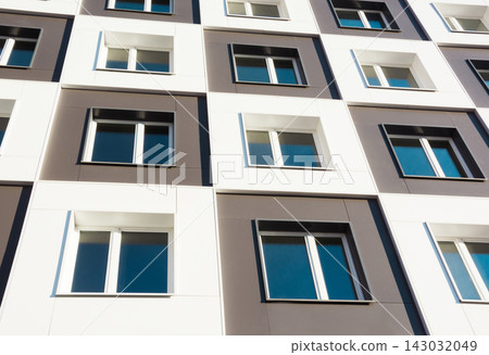 Modern and new apartment building. Photo of a tall block of flats against a blue sky. Modern and new apartment building. Photo of a tall block of flats against a blue sky. 143032049