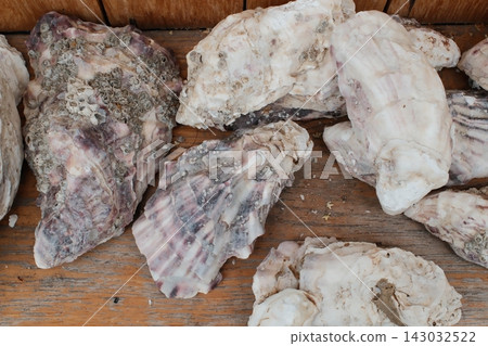 Fresh raw oysters sitting on a wooden surface during the daytime Fresh raw oysters sitting on a wooden surface during the daytime 143032522