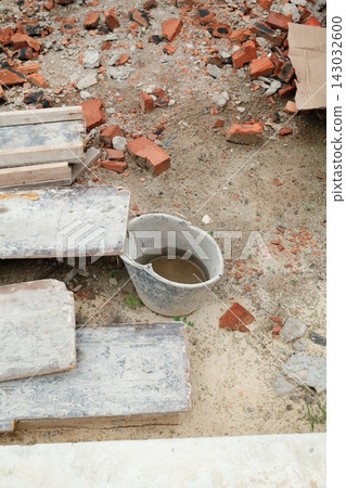 Plastic bucket filled with water placed on a construction site with brick debris Plastic bucket filled with water placed on a construction site with brick debris 143032600