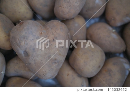 Heart shaped potato resting in a large pile of fresh brown potatoes Heart shaped potato resting in a large pile of fresh brown potatoes 143032652