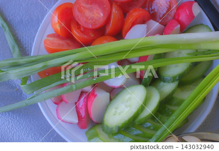 Fresh sliced vegetables with tomatoes and cucumbers on a white plate Fresh sliced vegetables with tomatoes and cucumbers on a white plate 143032940