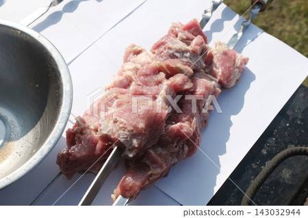 Raw pieces of pork meat on metal skewers ready for cooking outdoors Raw pieces of pork meat on metal skewers ready for cooking outdoors 143032944
