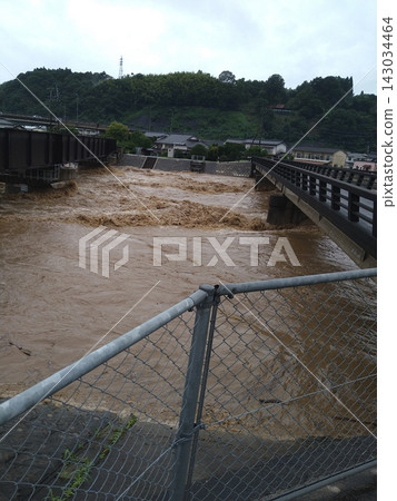 The muddy torrent and bridge swollen by heavy rain 143034464