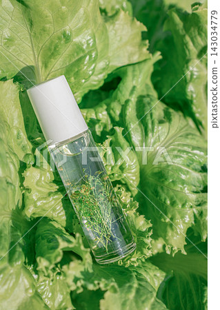 Natural oil-based perfume or serum in a roll-on bottle on lettuce leaves. Concept of organic cosmetics, clean ingredients, and aromatherapy Natural oil-based perfume or serum in a roll-on bottle on lettuce leaves. Concept of organic cosmetics, clean ingredients, and aromatherapy 143034779