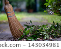 Straw Broom with Dry Leaves on Garden Path 143034981