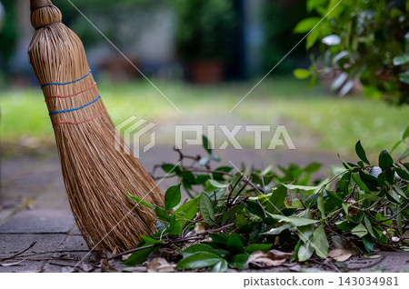Straw Broom with Dry Leaves on Garden Path 143034981