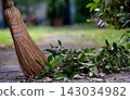 Straw Broom with Dry Leaves on Garden Path 143034982