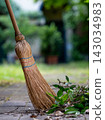 Straw Broom with Dry Leaves on Garden Path 143034983