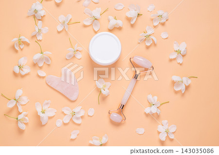 Facial massage set roller scraper guasha cosmetic oil serum face care on pastel pink background Facial massage set roller scraper guasha cosmetic oil serum face care on pastel pink background 143035086