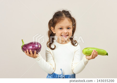 Happy child presenting organic vegetables, promoting healthy eating and nutrition with a joyful expression Happy child presenting organic vegetables, promoting healthy eating and nutrition with a joyful expression 143035200