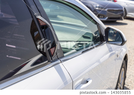 Close-up of rear passenger safety mirror unit on white car door frame Close-up of rear passenger safety mirror unit on white car door frame 143035855