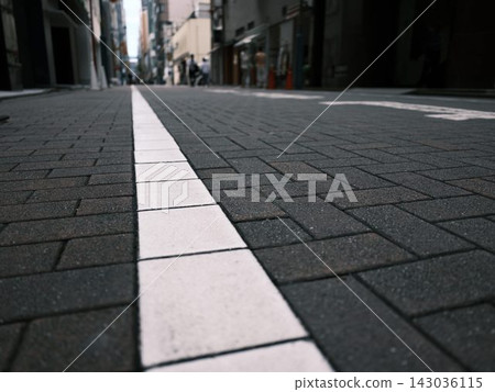 一條鋪著石板的城市街道,白色的線條一直延伸到遠方。 一條鋪著石板的城市街道,白色的線條一直延伸到遠方。 143036115
