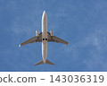 Passenger plane seen from below against a clear blue sky 143036319