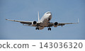 The plane lands. Airplane, passengers flying in the blue sky, preparing to land at the airport 143036320