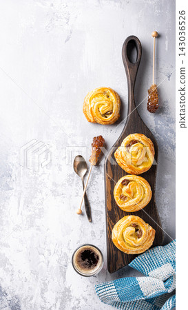 Freshly baked pastry rolls arranged on a wooden board with honey and coffee for a delightful breakfast Freshly baked pastry rolls arranged on a wooden board with honey and coffee for a delightful breakfast 143036526