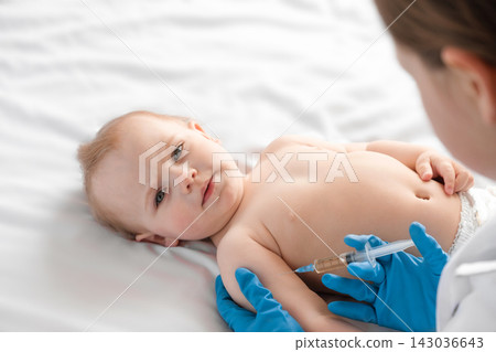 Doctor vaccinating baby in clinic. Little baby get an injection. Pediatrician vaccinating newborn baby. Vaccine for infant child. Child's Immunization, Children's Vaccination, Health concept Doctor vaccinating baby in clinic. Little baby get an injection. Pediatrician vaccinating newborn baby. Vaccine for infant child. Child's Immunization, Children's Vaccination, Health concept 143036643