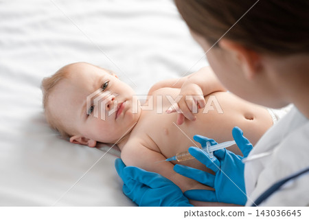 Doctor vaccinating baby in clinic. Little baby get an injection. Pediatrician vaccinating newborn baby. Vaccine for infant child. Child's Immunization, Children's Vaccination, Health concept Doctor vaccinating baby in clinic. Little baby get an injection. Pediatrician vaccinating newborn baby. Vaccine for infant child. Child's Immunization, Children's Vaccination, Health concept 143036645