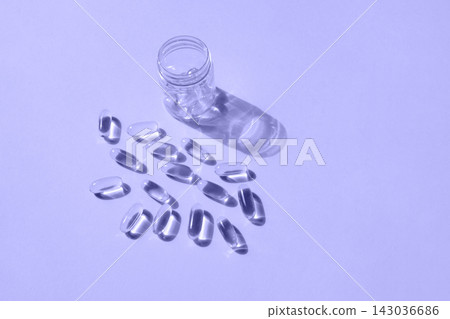 Pills and glass pill bottle on yellow background. Big golden tablets. Omega 3 capsules. Close up, top view. Health care concept. Healthy every day fatty acids nutritional supplement dosage. Flat lay 143036686